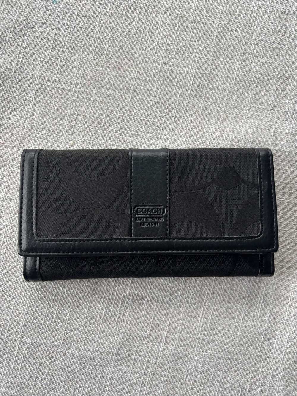 Coach signature checkbook wallet in black.